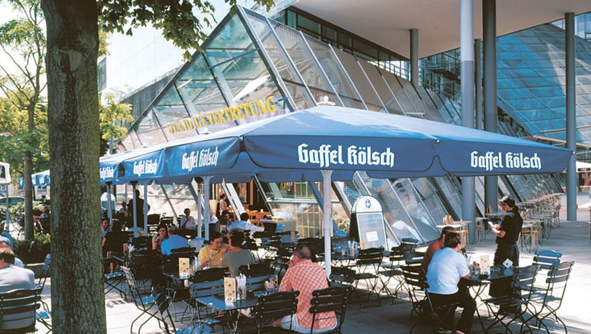 Hochwertige Sonnenschirme in der Gastronomie vs. kostenlose Brauereischirme